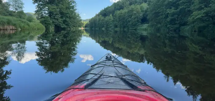 Blick vom Bug eines Kajaks den Fluss hinunter